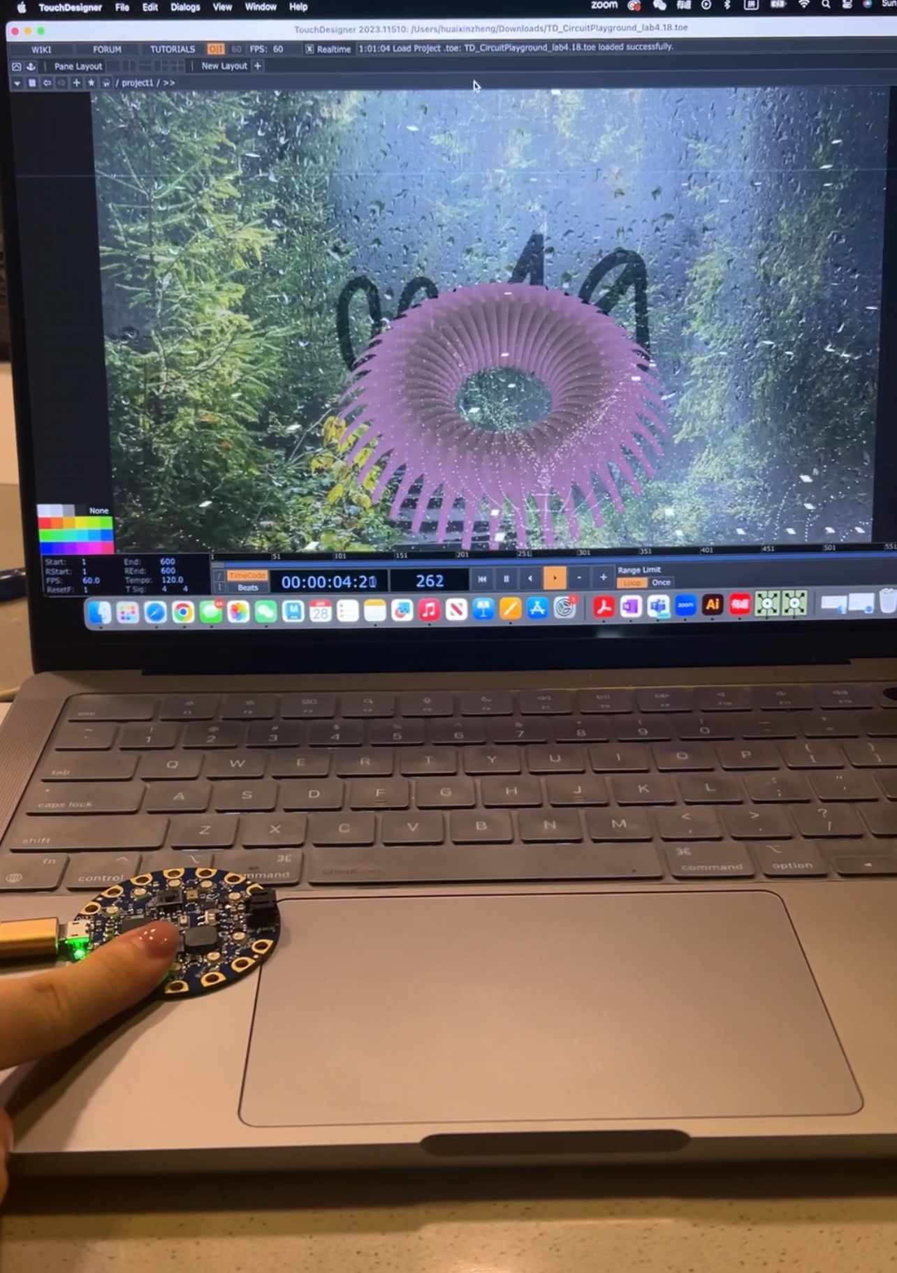 TouchDesigner visualization of a pulse-responsive flower beside a Circuit Playground microcontroller